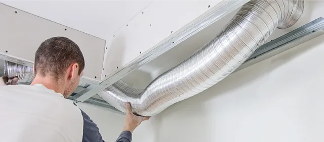 man installs air ducts for a client